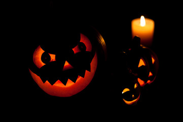 Three halloween pumpkins in the dark
