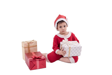Asian kid dress up as santa claus with gift boxes .