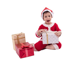 Asian kid dress up as santa claus with gift boxes .
