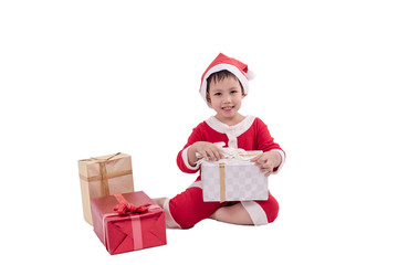 Asian kid dress up as santa claus with gift boxes .