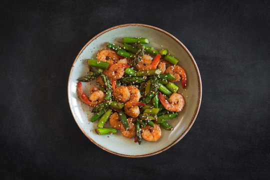 Salad with asparagus and shrimps in plate. Central composition