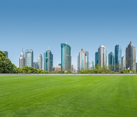 Obraz premium cityscape and skyline of shanghai from meadow in park