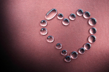 Heart shaped water drops on the red background