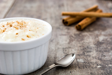 Arroz con leche. Rice pudding with cinnamon on wooden background
