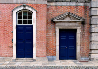 Blue closed doors on a brick facade of a building