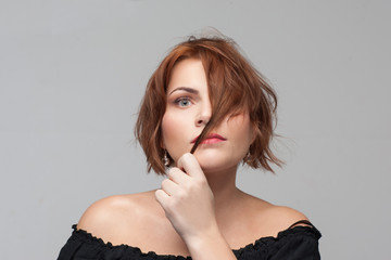 Ashamed of appearance. Hair problems. Shy young woman portrait on grey background with free space,...