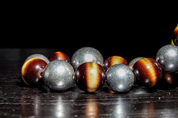 ound colored stone necklace on black table and background. selective focus
