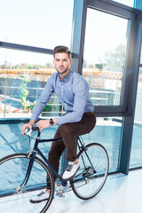 Fototapeta na wymiar young businessman with bicycle in office