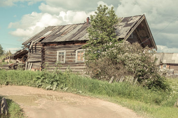 north Russian village Isady. Summer day, Emca river, old cottages on the shore, old wooden bridge. Abandoned building.