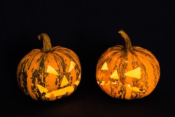 Beleuchtete Halloween Kürbisse vor schwarzem Hintergrund
