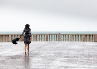 donna a piedi scalzi corre sotto la pioggia