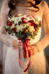 Bride with winter bouquet of fresh red and white flowers. Winter wedding