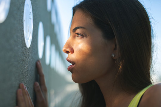 Side view of a young woman standing outside.