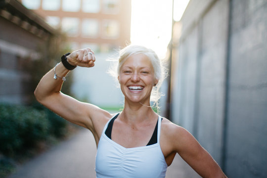 portrait of vibrant young female exercising in urban city alley