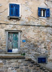 Fototapeta na wymiar Haus mit blauen Fenstern und alter Türe in Kroatien