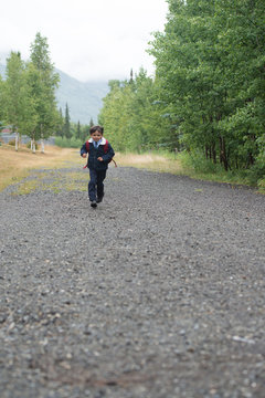 boy runs down a path on his way to school