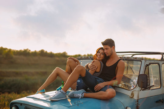 Couple Sitting On Truck In Countryside