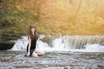 Brunette in a black dress in the water