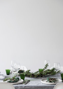 Dining table setting with white plates and green glasses