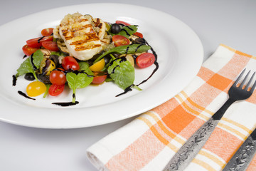 Grilled Halloumi Cheese poured with garlic olive oil salad witch grilled eggplant, cherry tomatoes, black olives and spinach. healthy food. Close up