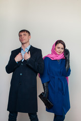 Stylish guy and attractive woman posing against white background autumn season