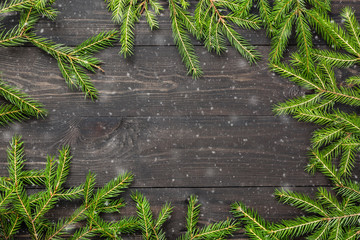 Christmas fir tree on a dark wooden board with snow. Christmas or new year frame for your project with copy space.