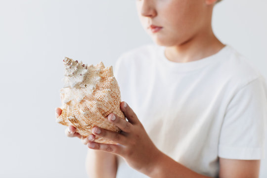 child holding a conch shell