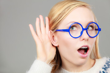 Woman listening carefully with hand close to ear