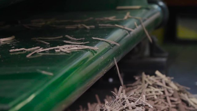Paper shavings close up, waste from the production of cardboard boxes. Machine carves cardboard boxes from sheets of cardboard. Manufacture of cardboard boxes. Footage with sound.