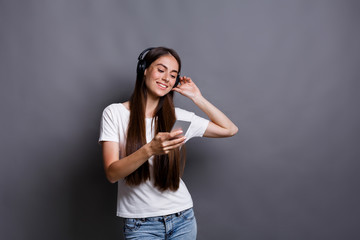 Woman listen to music in earphones, studio shot