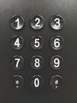 Numbered push buttons on a vending machine with braille letters