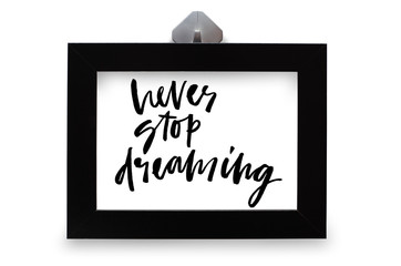 Never stop dreaming. Handwritten text. Modern calligraphy. Inspirational quote. Black photo frame