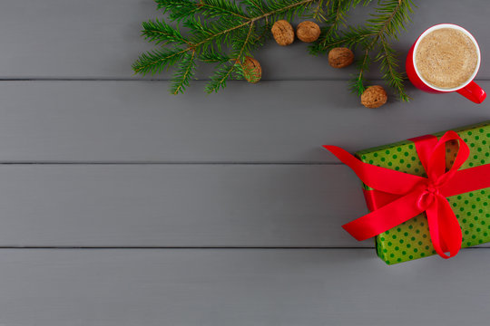 Box in green dotten paper for xmas, new year on gray wooden background