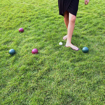 A Woman's Feet Measuring The Distance Between Bocce Balls During A Game