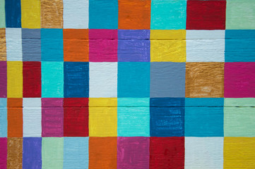 Multicolored checkerboard pattern on wood background