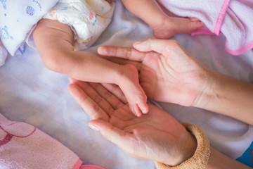 small feet of baby carry by mom hands
