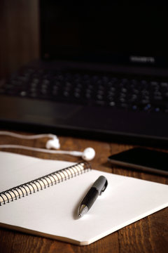 a desk with a notebook laptop pencil coffee phone and headphones writer's tabel 
