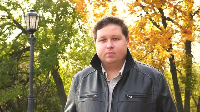 Portrait of caucasian man with black leather jacket looking at camera with blank expression