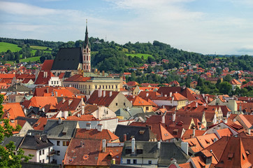 Fototapeta premium Red tile roofs cityscape. Church of Saint Vitus- UNESCO World Heritage Site. Summer sunny day. Cesky Krumlov (Krumau), Czech Republic