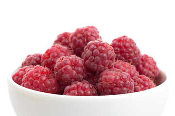 Raspberries on white plate on white background isolated