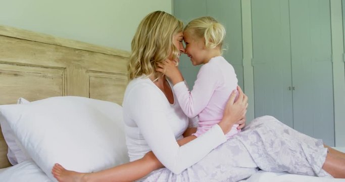 Mother and daughter having fun in the bedroom 