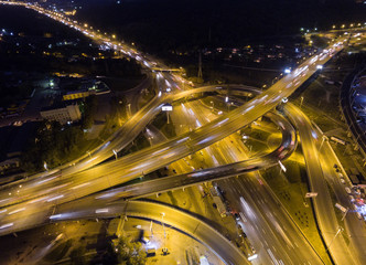 Fototapeta na wymiar Vertical top down aerial view of traffic on freeway interchange at night.