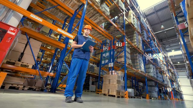 A low view on concentrated warehouse inspector. 