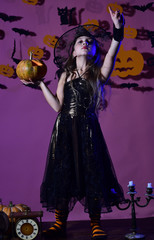 Little witch wearing black hat. Kid in spooky witches costume