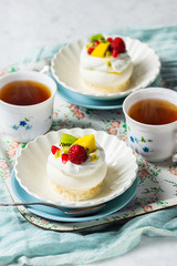Mini Pavlovas, a Dessert Made From Meringues Topped with Whipped Cream and Fruit, and Hot Tea