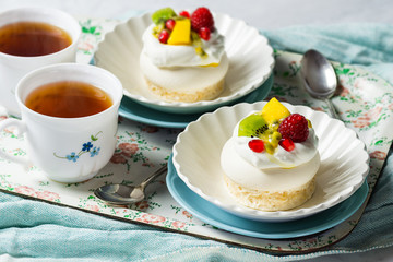 Mini Pavlovas, a Dessert Made From Meringues Topped with Whipped Cream and Fruit, and Hot Tea
