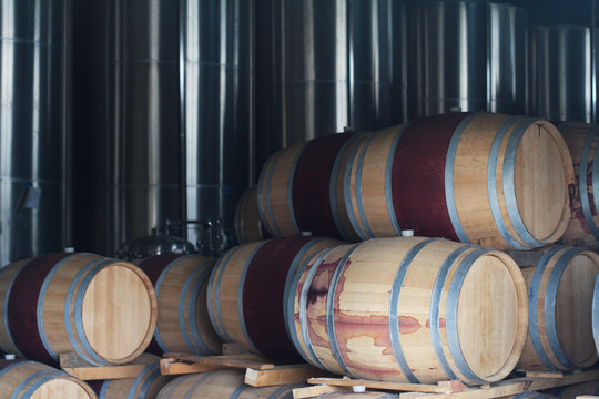 wine barrels next to chrome metallic tanks
