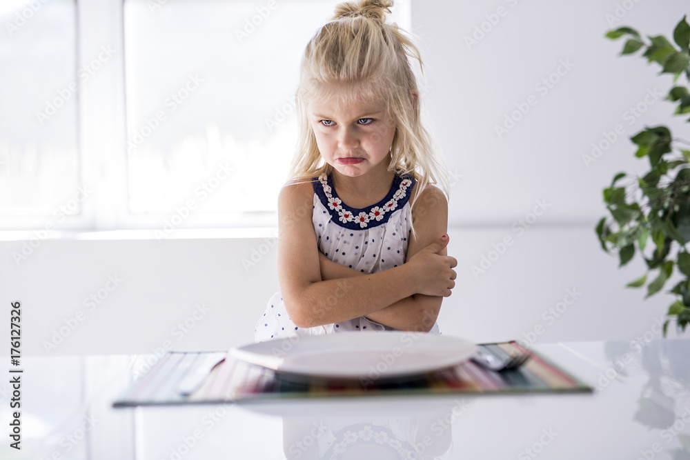 Wall mural Furious little girl waiting for dinner