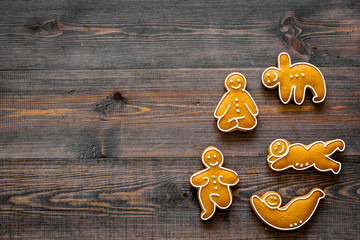 Gingerbread cookies in shape of yoga asanas on dark wooden background top view copyspace