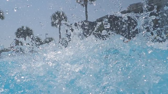 Little boy going down waterslide at swimming pool on vacation at resort